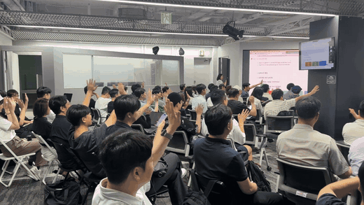 23기 오프모임에서 약 300명의 AI 얼리어답터가 발표를 들으며 손을 든 현장